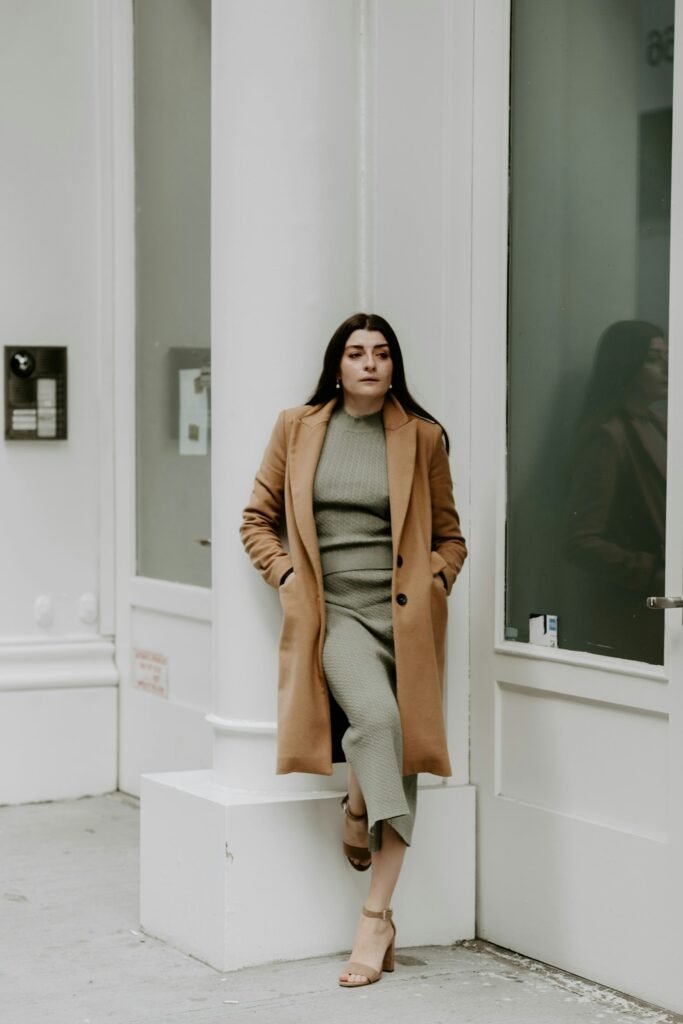 Manteau camel long porté sur un pantalon gris
