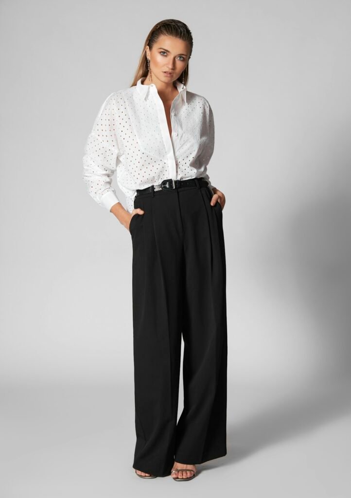 Pantalon large noir porté avec une chemise blanche