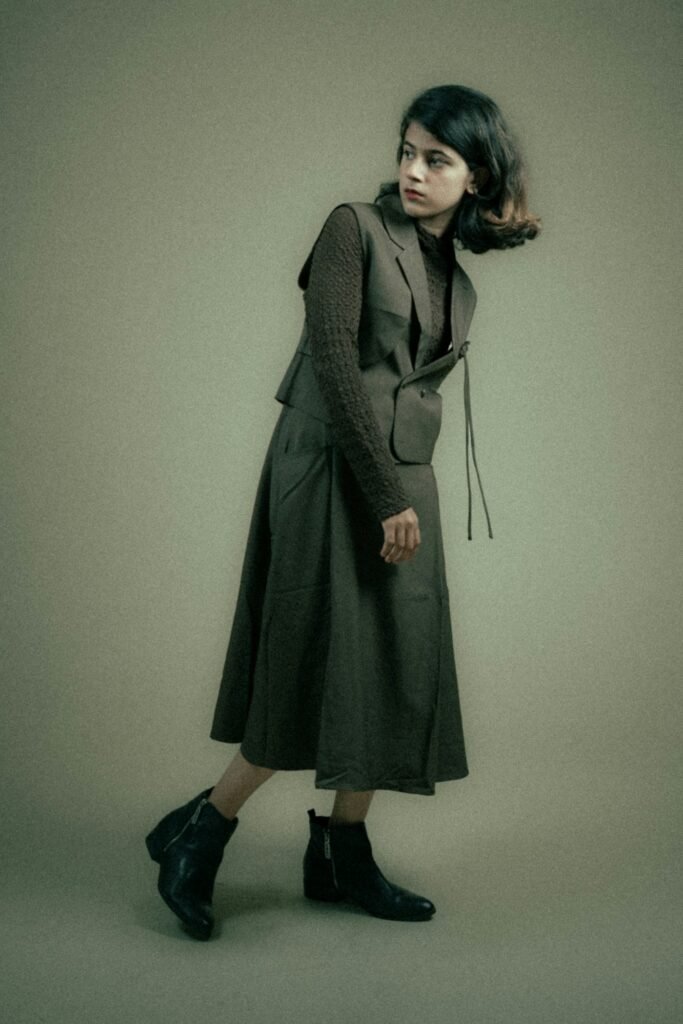 Robe midi olive portée sur fond sauge